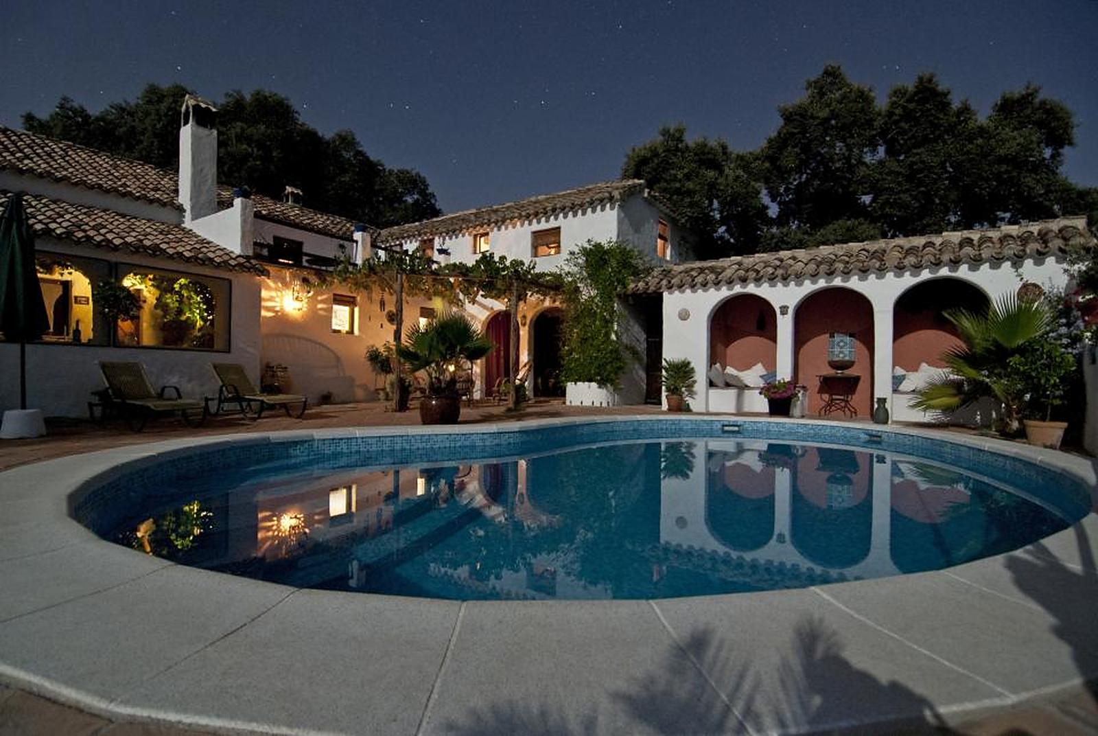 A villa and pool lit up in the evening
