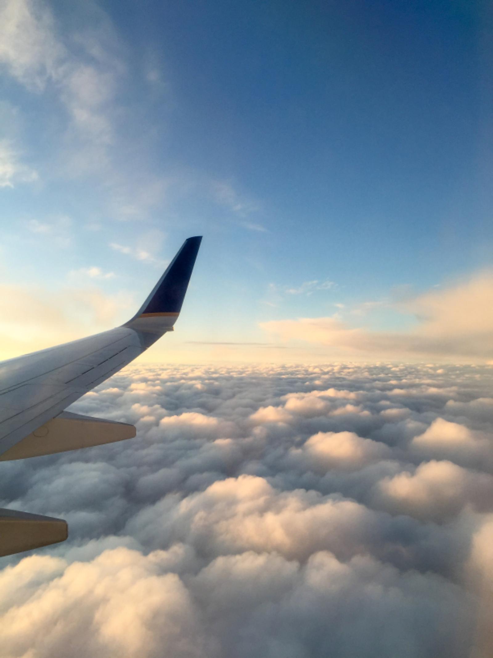 An aircraft wing above the clouds
